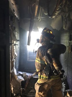 A firefighter is engaged in overhaul.