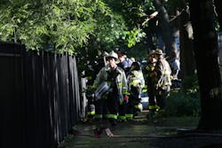 Firefighters wrap up after a devastating fire. Firefighters wrap up after a devastating fire.