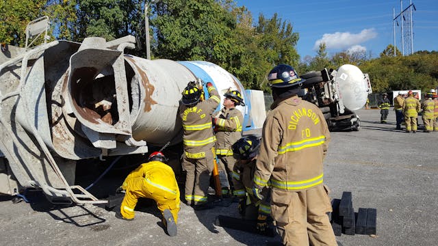 Students use techniques they learned during a big rig rescue class at Firehouse Expo to lift a cement truck off a Mustang convertible.