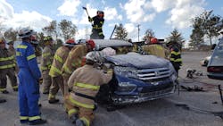 Students learn new car extrication tips during hands-on training at Firehouse Expo in Nashville. Students were asked by the instructor to peel the first section of the roof off and a firefighter took to the top of the rig to make a crease to bend the roof back.