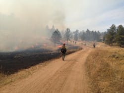 A firefighter monitors the prescribed burn in Red Feather Lakes. A firefighter monitors the prescribed burn in Red Feather Lakes.