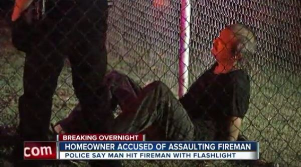 Police detain Dale Parsons at the scene of the house fire in Tulsa Monday night.