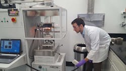 A Gore associate burns a portion of the company's Parallon liner system in a Cone Calorimeter to measure the fabric's heat-release characteristics. The fabric was subjected to about 1,700 degrees Fahrenheit in the device. A Gore associate burns a portion of the company's Parallon liner system in a Cone Calorimeter to measure the fabric's heat-release characteristics. The fabric was subjected to about 1,700 degrees Fahrenheit in the device.