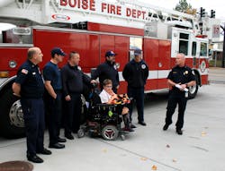 RIT Safety Solutions LLC of Twinsburg, OH, has donated an EZ-Don rescue harness to the Boise Fire Department. Receiving the gift with the firefighters is JoJo Tuinstra, 12, of Kuna, ID.