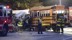 Firefighters and police look over the scene where commuter bus and school bus collided early Tuesday.