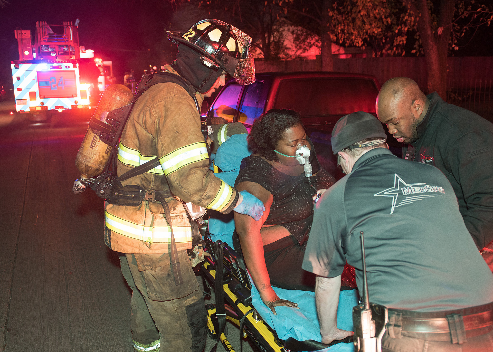 Fort Worth firefighters and MedStar paramedics assist a resident to the ambulance.