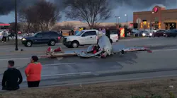 A large section of a plane lays in the middle of a road.