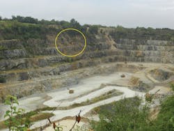 An overall photo of the vast quarry operation. The overturned dump truck is pictured in the yellow circle. Emergency vehicles can be seen lined along the south rim at the top left. The large quarry haul trucks are seen 350 feet down.
