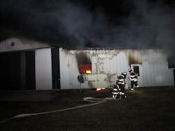 Firefighters from Germantown Engine 62 advance a 2 1/2-inch handline to the building.