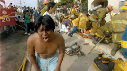 A young man weeps in May 1993 after seeing a dead child in front of an apartment house devastated by a fire in the Westlake district of Los Angeles, Calif. Los Angeles police have announced the arrests of three people in connection with the fire.