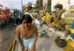 A young man weeps in May 1993 after seeing a dead child in front of an apartment house devastated by a fire in the Westlake district of Los Angeles, Calif. Los Angeles police have announced the arrests of three people in connection with the fire.