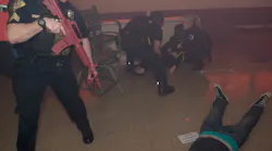 A police officer looks over the scene as two firefighters prepare to a remove a victim during the active shooter demonstration.