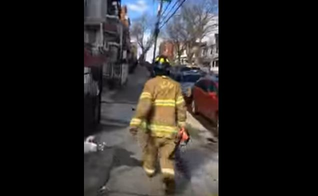 A witness captured video of the woman wearing a Jersey City firefighter's PPE and carrying a flashlight.