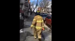 A witness captured video of the woman wearing a Jersey City firefighter's PPE and carrying a flashlight.