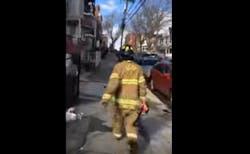 A witness captured video of the woman wearing a Jersey City firefighter's PPE and carrying a flashlight. A witness captured video of the woman wearing a Jersey City firefighter's PPE and carrying a flashlight.