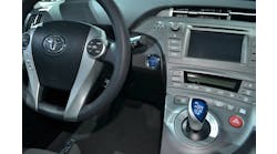 This 2015 Toyota Prius has a keyless ignition start/stop push button, an electronic parking brake button on the center console, and a joystick-type gear selector.