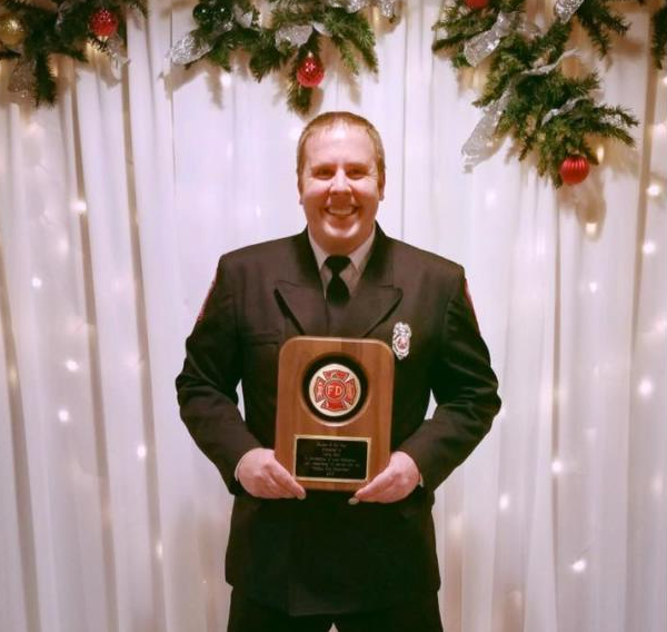 Firefighter/Paramedic Justin Root proudly displays his 2016 Rookie of the Year Award.