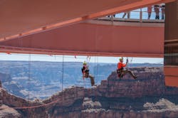 Two level III rope access technicians meet at the halfway point pre-rigging protection lines under the Grand Canyon Skywalk. The Skywalk is a glass walkway cantilever bridge built over the Grand Canyon in 2007. The underside of the glass had never been cleaned, and Abseilon USA was contracted to do this high-exposure job. Two level III rope access technicians meet at the halfway point pre-rigging protection lines under the Grand Canyon Skywalk. The Skywalk is a glass walkway cantilever bridge built over the Grand Canyon in 2007. The underside of the glass had never been cleaned, and Abseilon USA was contracted to do this high-exposure job.
