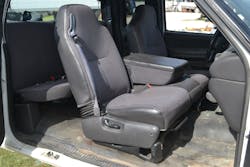 The passenger front seat of this 2002 Ford pickup truck clearly shows the seatback bracket and hinge area where the seatback joins to the lower seat cushion/frame section. Note the manual recline lever on the side of the seat frame.