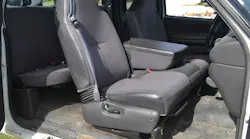 The passenger front seat of this 2002 Ford pickup truck clearly shows the seatback bracket and hinge area where the seatback joins to the lower seat cushion/frame section. Note the manual recline lever on the side of the seat frame.