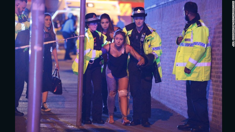 An injured concert-goer is helped by police and emergency responders on Monday, May 22, 2017 at the Manchester Arena in Manchester, England after a suicide bombing.