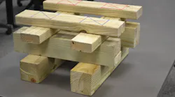 Markings on the top layer of this training cribbing indicate the 12 1/4 square inches of load-bearing contact at each of the four points on this 2 x 4 and 4 x 4 double-box crib. Multiplying 12 1/4 x 500 psi gives this soft wood box crib its 24,500-pound capacity when all four contact points are evenly loaded. Each wood piece is positioned so the load is applied perpendicular or in a cross-grain fashion. Also note the 3 1/2-inch end “overhang” of each layer in the stack. Photo by Ron Moore