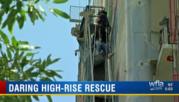 A Sarasota firefighter rappels down to rescue a construction worker who became trapped when the scaffolding he was on malfunctioned Monday.