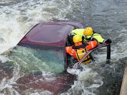 Rescuers who access the car by wading or swimming can break out windows and also open doors on the downstream (in the eddy) side. Notice that the roof is dented in, the first rescuer swimming to the car should tell the victims that he is going to dent the roof in. This provides a safer work area.