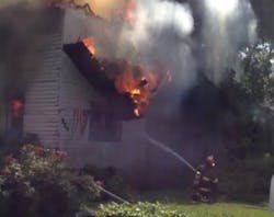 A section of roof falls before narrowly missing an Anderson firefighter working to tackle a fire during which neighbors rescued an elderly woman Tuesday. A section of roof falls before narrowly missing an Anderson firefighter working to tackle a fire during which neighbors rescued an elderly woman Tuesday.