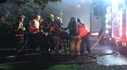 Chattanooga firefighters provide medical aid to a woman rescued from a house fire.