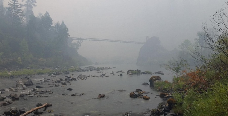 A smoky haze hovers in Oregon's Illinois River Valley as efforts to contain the massive Chetco Bar Fire continue.
