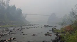 A smoky haze hovers in Oregon's Illinois River Valley as efforts to contain the massive Chetco Bar Fire continue.