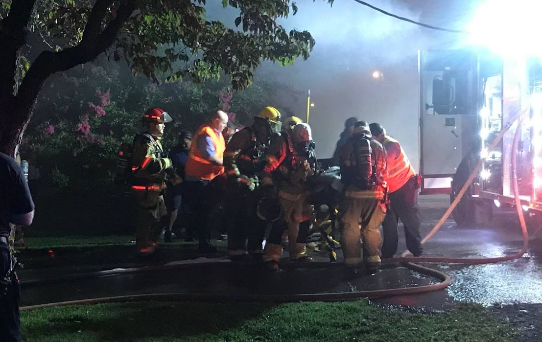 Chattanooga firefighters attend to a woman they pulled from a burning home Wednesday, which was one of four fires in Lookout Valley inside of a week.