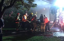 Chattanooga firefighters attend to a woman they pulled from a burning home Wednesday, which was one of four fires in Lookout Valley inside of a week.