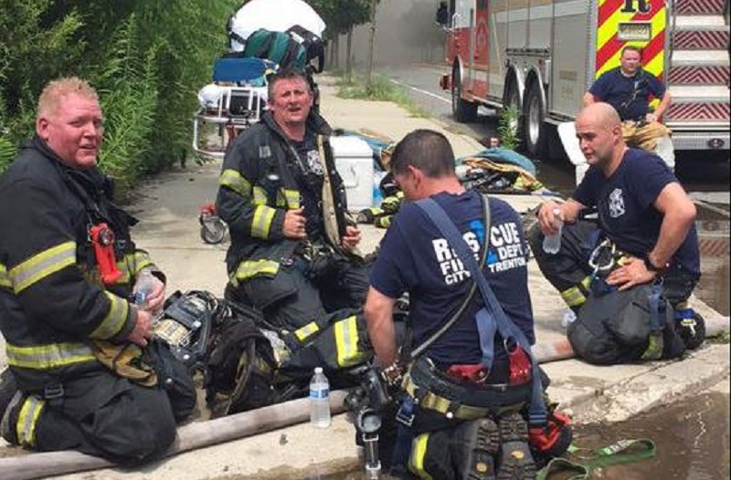A group of Trenton firefighters cool down and hydrate during a call in July.