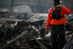 A search worker takes a quick respite as search teams canvas through the debris of mobile homes after the Journey&apos;s End Mobile Home Park in Santa Rosa, CA, was destroyed by wildfire, on Friday, Oct. 13, 2017.