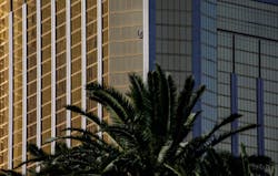 A curtain blows out of a broken window where a gunman opened fire from an upper story of the Mandalay Bay resort on a country music festival across the street on the Las Vegas Strip on Sunday night, leaving at least 58 dead and more than 500 injured.