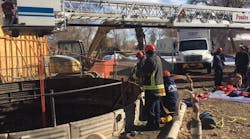 Photo 1: The bucket of Tower 1 was centered over the access point and used as the high anchor point for the 4:1 hauling system. Photo 1: The bucket of Tower 1 was centered over the access point and used as the high anchor point for the 4:1 hauling system.