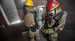 A firefighter refills an air bottle during a high-rise fire using Firefighter Air Replenishment System (FARS) quick fill.