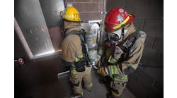 A firefighter refills an air bottle during a high-rise fire using Firefighter Air Replenishment System (FARS) quick fill.