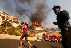 Amanda Leon and husband Johnny Leon watch as firefighters fight to save multi-million dollar homes along Cobblestone Drive Tuesday midday after a fast-moving swept into Ventura destroying many homes. Amanda Leon and husband Johnny Leon watch as firefighters fight to save multi-million dollar homes along Cobblestone Drive Tuesday midday after a fast-moving swept into Ventura destroying many homes.