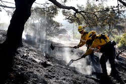 Firefighters work to put out a brush fire in Malibu, CA, in the hills above Pt. Dume on Thursday, Dec. 7, 2017.