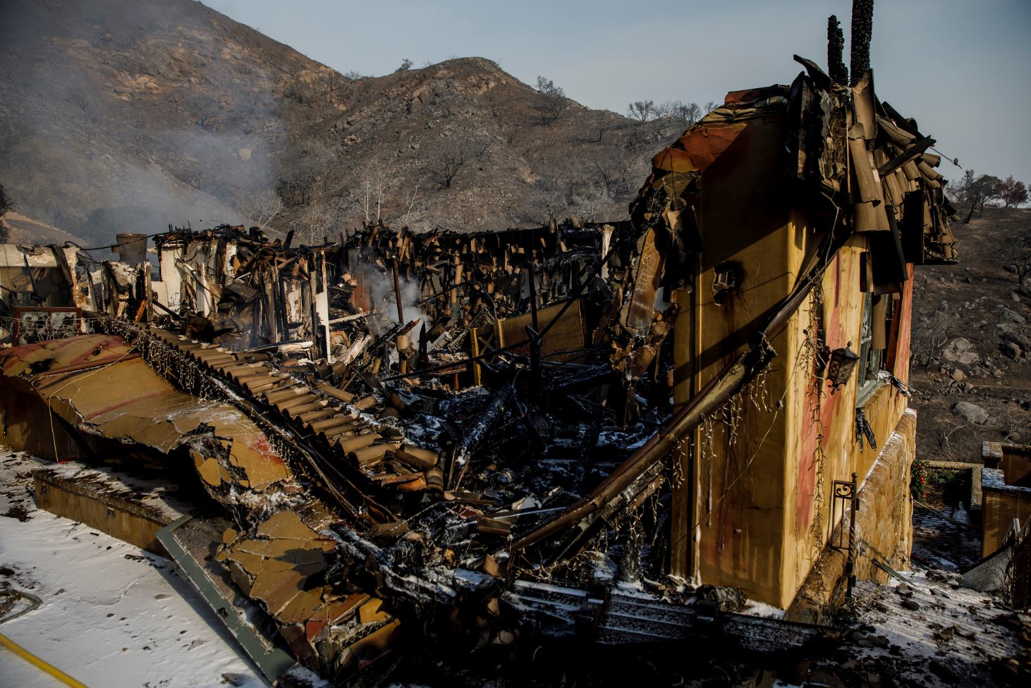 Heat and smoke rise from the rubble of a home destroyed by the Thomas Fire on Sunday, Dec. 17, 2017 in Montecito, CA.