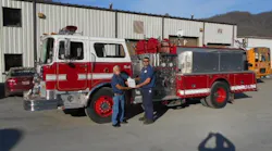 Howard Peiffer, retired chief of Palm Coast, FL, Fire Department, hands the title of a 1984 Mack to to Sunshine Volunteer Fire Chief Steven Hatfield. The truck was donated by the City of Palm Coast.