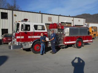 Howard Peiffer, retired chief of Palm Coast, FL, Fire Department, hands the title of a 1984 Mack to to Sunshine Volunteer Fire Chief Steven Hatfield. The truck was donated by the City of Palm Coast.