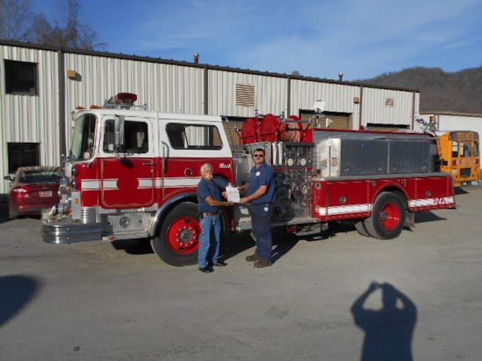 Howard Peiffer, retired chief of Palm Coast, FL, Fire Department, hands the title of a 1984 Mack to to Sunshine Volunteer Fire Chief Steven Hatfield. The truck was donated by the City of Palm Coast.