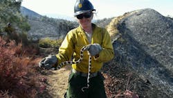 Firefighter Hannah Key moves a snake from harms way during the Pilot fire in the summer of 2016 in Sequoia National Forest. Like other female firefighters, Key finds standard work uniforms ill fitting.