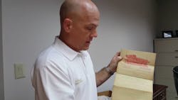 Dalton, GA, Fire Chief Todd Pangle holds up a remarkably well preserved purchase contract for a hook-and-ladder fire truck purchased by the city in 1901. Dalton, GA, Fire Chief Todd Pangle holds up a remarkably well preserved purchase contract for a hook-and-ladder fire truck purchased by the city in 1901.