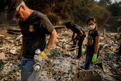 Jeff Lipscomb, from left, Gabriel Lipscomb, 17, and Rachel Lipscomb, 11, look for items to recover in the wreckage of their burned home on Dec. 6, 2017, in Ventura, CA.
