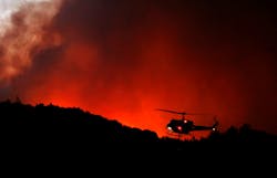A helicopter prepares to drop water on a fire threatening the Oakmont community along Highway 12 in Santa Rosa, CA, on Oct. 13, 2017. A helicopter prepares to drop water on a fire threatening the Oakmont community along Highway 12 in Santa Rosa, CA, on Oct. 13, 2017.
